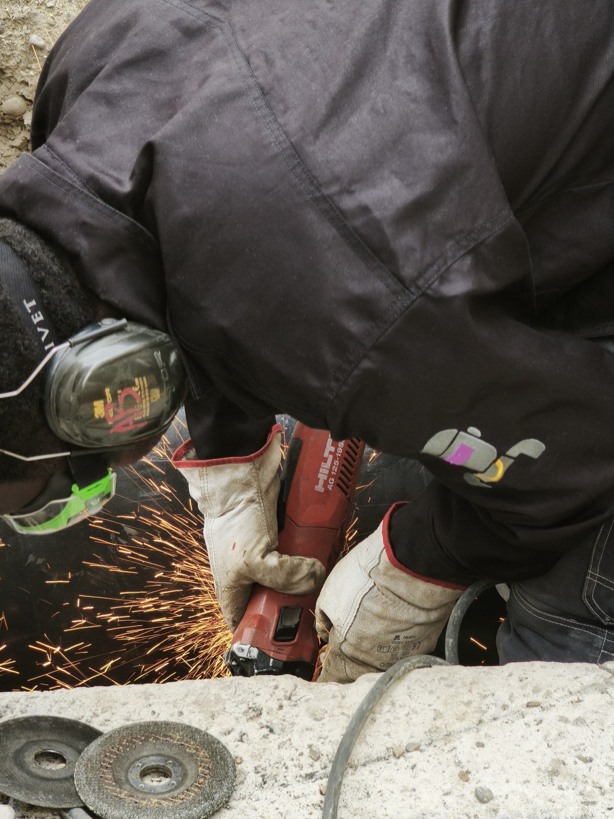 An angle grinder at work, sparks and gloves