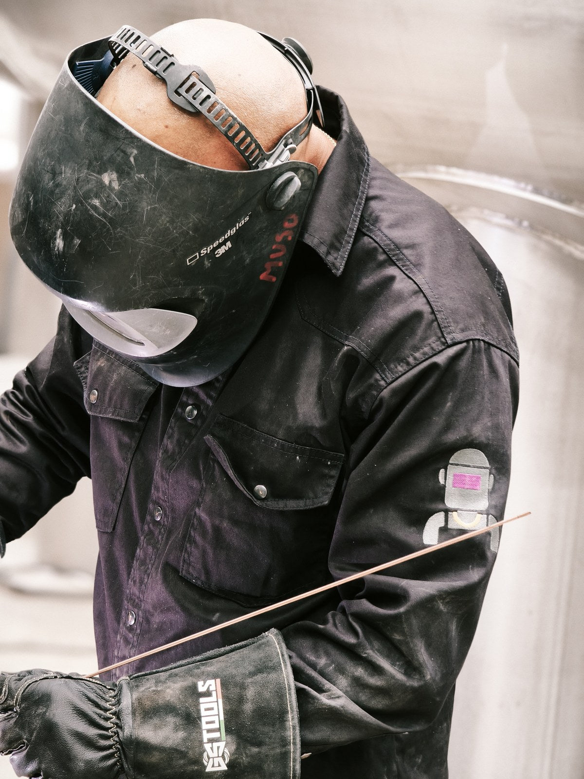 Filler rod in hand, welding gloves